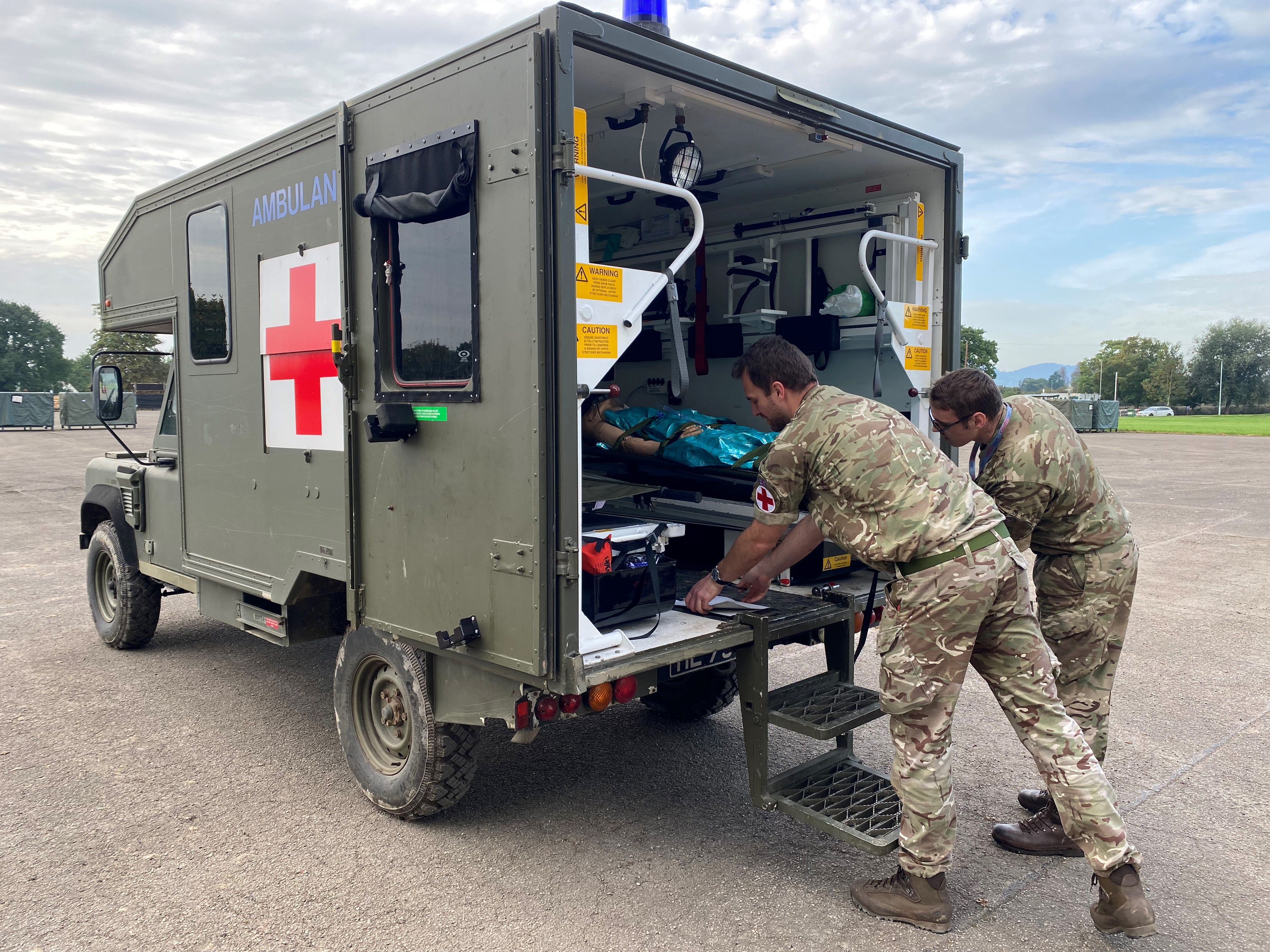 Photo - Tactical Medical Wing on Exercise Athena Dragon 23. Image shows two medical personnel working at the back of a field ambulance